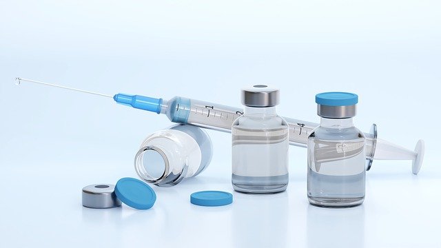 Imagem de recipientes de vacina e seringa com agulha